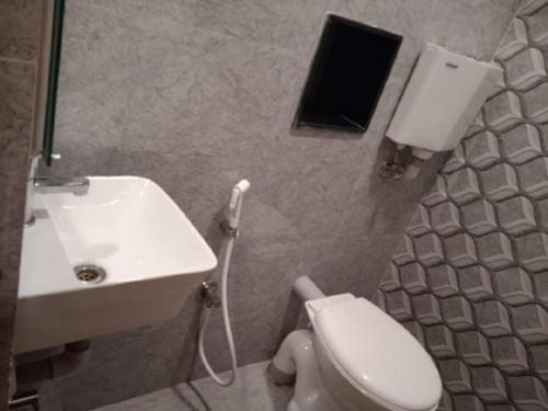a bathroom with a white toilet and a sink at Nestlay Rooms Ambattur in Chennai