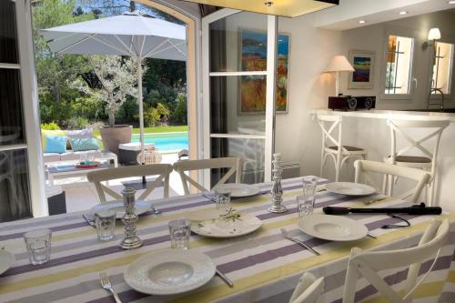 une salle à manger avec une table et des chaises et une cuisine dans l'établissement Ma villa en Provence villa de standing et piscine Domaine de Pont-Royal, à Mallemort