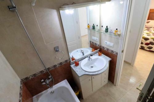 een badkamer met een wastafel, een douche en een toilet bij El Cid apartamento soleado vista panorámica al mar y piscina comunitaria in San Juan de los Terreros