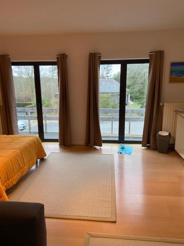 Sint-Genesius-Rodeにあるnarcissesのベッドルーム1室(ベッド1台付)、ガラスのスライドドアが備わります。