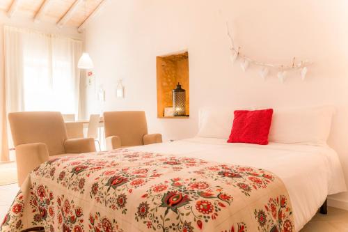 Un dormitorio con una cama con una almohada roja. en Cercas Velhas, en Sagres