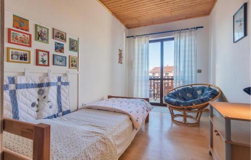 a bedroom with a bed and a chair and a window at Pet Friendly Apartment In Fazana With Wifi in Fažana