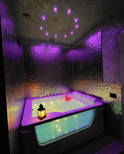 a purple bathroom with a bath tub with a lamp at Hotel Relais Dei Papi in Rome