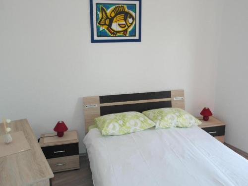 a bedroom with a bed with two night stands and two lamps at Apartments Račić in Bol