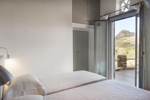 a bedroom with a bed and a sliding glass door at Tinos Pigeon House by TinosHost in Tzádhos