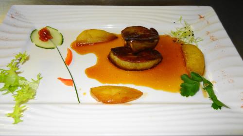 a white plate with a dish of food on it at Logis Hôtel Restaurant Le Chalet du Mont Roland in Dole