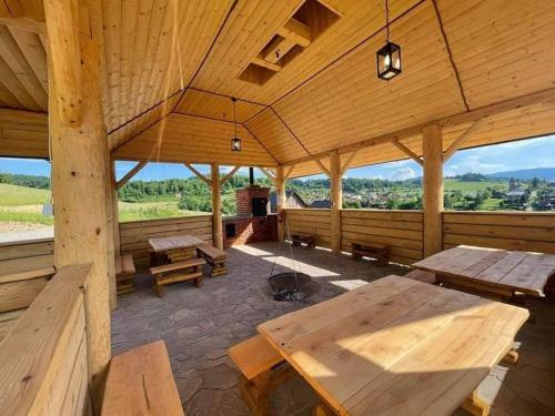 a large wooden pavilion with wooden tables and benches at RESET INN in Zawóz