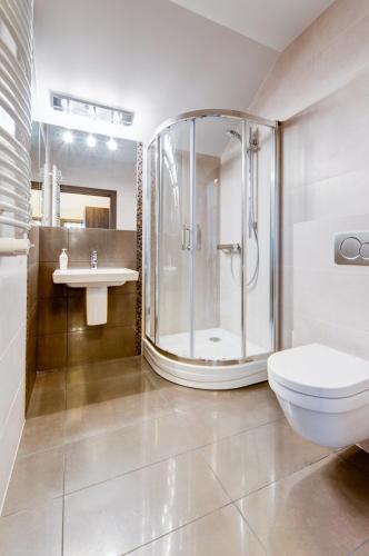 a bathroom with a shower and a toilet and a sink at Hotel Figa in Plewiska