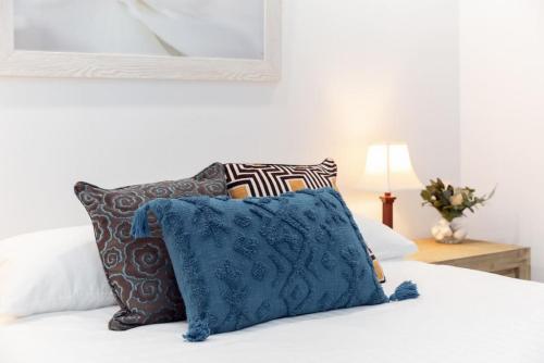 a white bed with pillows and a blue pillow at A3 Modern Apt with Free Parking and Private Bathroom in Perth