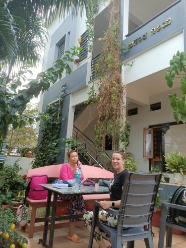 two people sitting at a table in front of a building at Arjun Homestay in Hampi