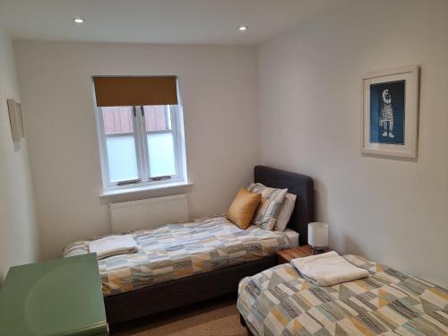 a bedroom with two beds and a window at Laston Mews in Ilfracombe