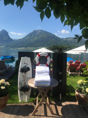 a table with towels on it next to a surfboard at Hotel Furian in St. Wolfgang
