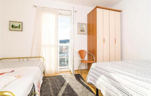 a bedroom with two beds and a window at Nice Apartment In Dubrovnik With 2 Bedrooms And Wifi in Dubrovnik