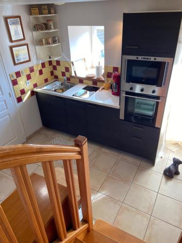 a kitchen with a stove and a sink in it at Gîte Losten Ar Goguès in Trédarzec