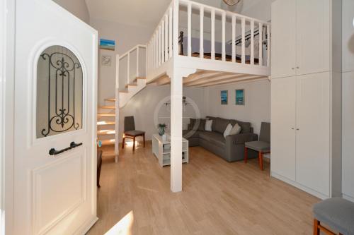 a living room with a staircase and a couch at Ava in Ermioni