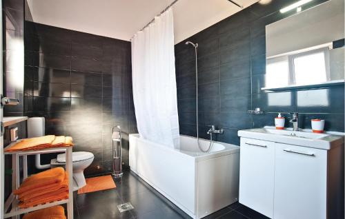 a bathroom with a tub and a toilet and a sink at 2 Bedroom Nice Apartment In Vodnjan in Vodnjan
