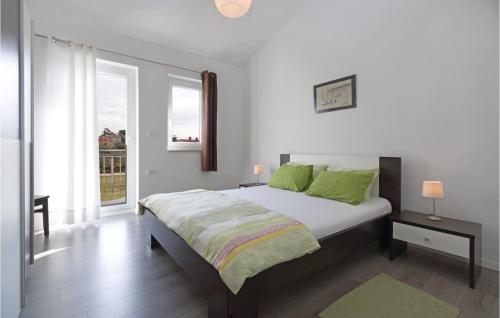 a white bedroom with a large bed with green pillows at 2 Bedroom Nice Apartment In Vodnjan in Vodnjan