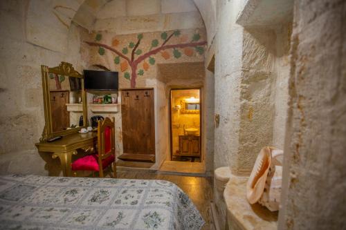 1 dormitorio con 1 cama y escritorio en una habitación en Royal Cave Hotel en Ürgüp