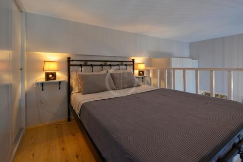 a bedroom with a bed and two lamps on a balcony at Ava in Ermioni