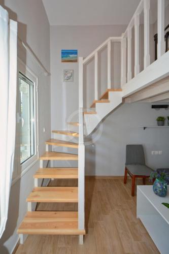 a staircase in a home with white walls and wooden floors at Ava in Ermioni