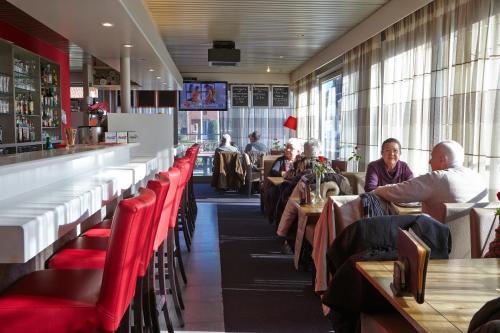 a group of people sitting at tables in a restaurant at Vivaldi Hotel in Westerlo