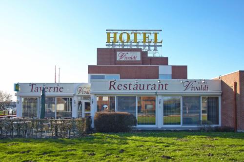 a hotel with a sign on top of a building at Vivaldi Hotel in Westerlo