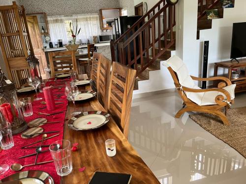 a dining room with a table with a red table runner at SOUTH HILL VILLA in Mahe