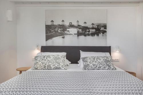 a bedroom with a bed with a large picture on the wall at Kostantis Town Suites in Mýkonos City
