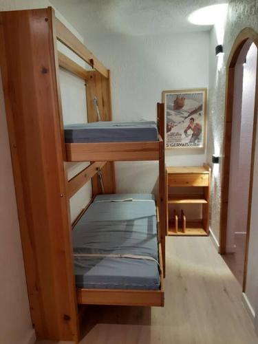 une chambre avec trois lits superposés dans une pièce dans l'établissement Appartement meublé avec vue sur les montagnes et piscine l'été, à Saint-Gervais-les-Bains
