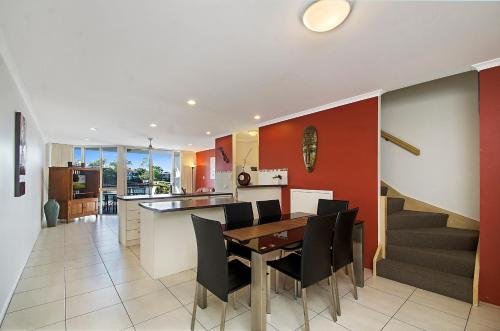 a kitchen and dining room with a table and chairs at Portside Noosa Waters in Noosaville