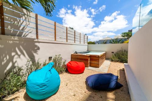 two blue and red bags sitting next to a wall at One Bay Residence - Apartment 2 - Apartment in Pereybere in Pereybere