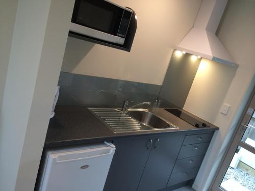a small kitchen with a sink and a microwave at Rolleston Highway Motel in Rolleston