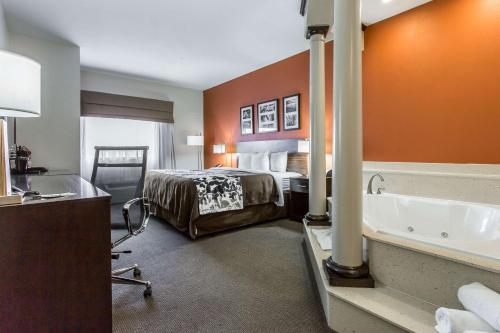 a hotel room with a bed and a bath tub at Sleep Inn & Suites Lubbock West in Lubbock