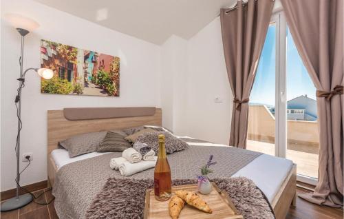a bedroom with a bed with a table and a window at Awesome Apartment In Biograd With Kitchen in Biograd na Moru