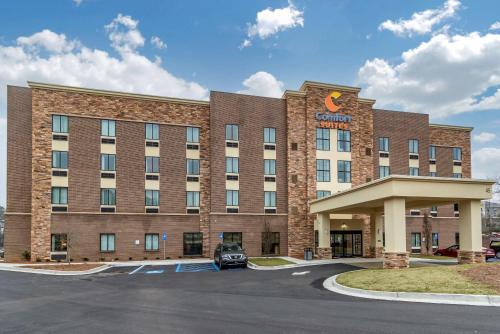 a hotel with a car parked in a parking lot at Comfort Suites in Newnan
