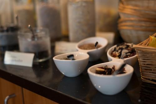 Un mostrador con cuencos de comida sobre una mesa. en Hotel Haus Schons, en Mettlach