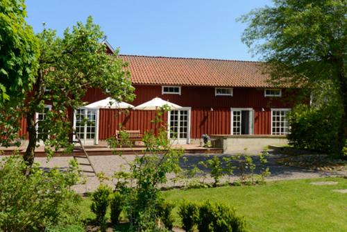uma casa vermelha com um jardim em frente em Säbyholms Gård em Laholm