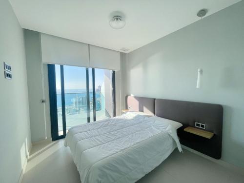ein Schlafzimmer mit einem großen Bett und einem großen Fenster in der Unterkunft Sunset and Relax in Benidorm