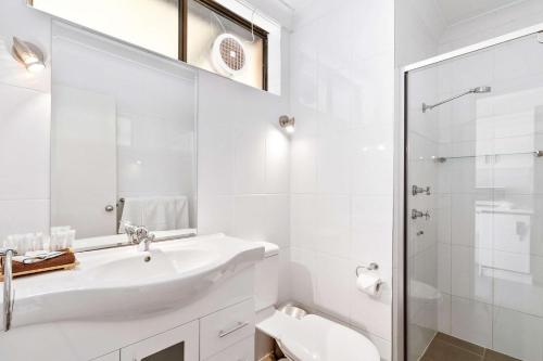 a white bathroom with a sink and a shower at Quality Inn Dubbo International in Dubbo
