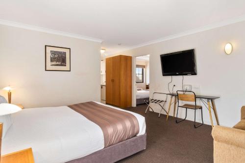 a hotel room with a bed, television and a desk at Quality Inn Dubbo International in Dubbo