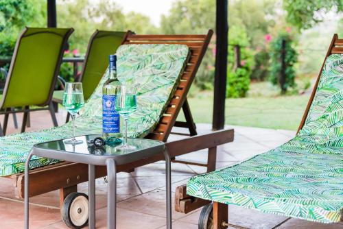 a table with a bottle of water and two chairs at Olive Tree Farm in Magaliesburg