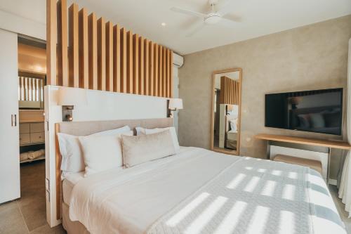 a bedroom with a large bed and a flat screen tv at Penthouse H70 St Antoine Residence in Île dʼAmbre