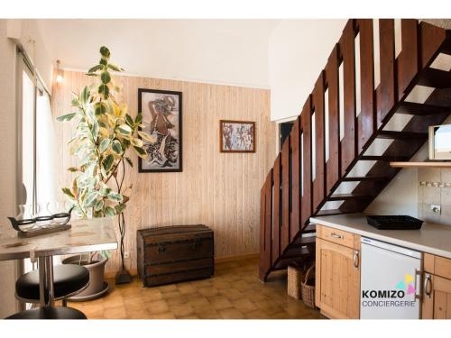 un salon avec un escalier doté d'une table et d'un sidx de table dans l'établissement Charmant duplex face à la mer, à Port-Leucate