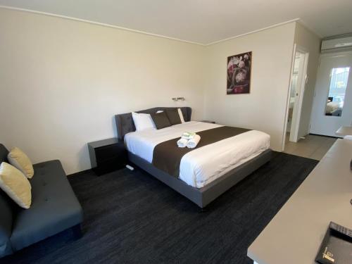 a hotel room with a bed and a couch at Warrina Motor Inn Wodonga CBD in Wodonga