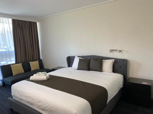 a hotel room with a large bed and a couch at Warrina Motor Inn Wodonga CBD in Wodonga
