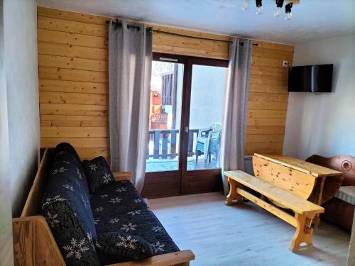 a living room with a couch and a window at Appartement meublé avec vue sur les montagnes et piscine l'été in Saint-Gervais-les-Bains