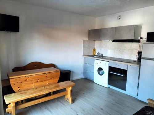 a kitchen with a bench and a washer and dryer at Appartement meublé avec vue sur les montagnes et piscine l'été in Saint-Gervais-les-Bains