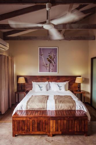 a bedroom with a large bed with a wooden headboard at Bushveld Terrace Safari Hotel, Lodge & Spa in Phalaborwa