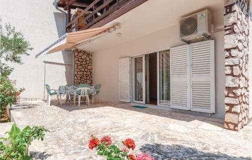 a house with a patio with a table and chairs at Two-Bedroom Apartment In Jadrija in Jadrija