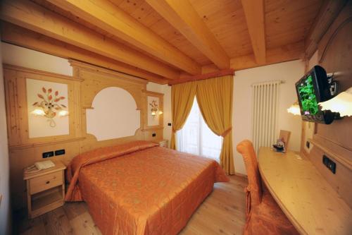 - une chambre avec un lit et une télévision dans l'établissement Residence Garnì Il Giglio, à Commezzadura